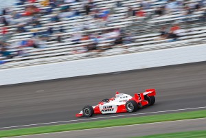Image of Indycar going around track at high speed