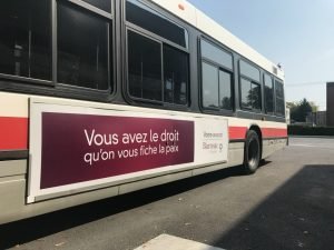 Ad advertisement in French on the side of a public bus