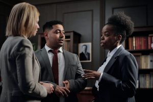 Three individuals in suits having a conversation in a legal office